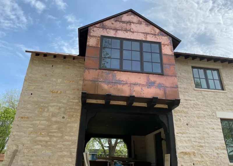 Copper metal panel facade on a stone building for Roof Repair in Pecan Plantation