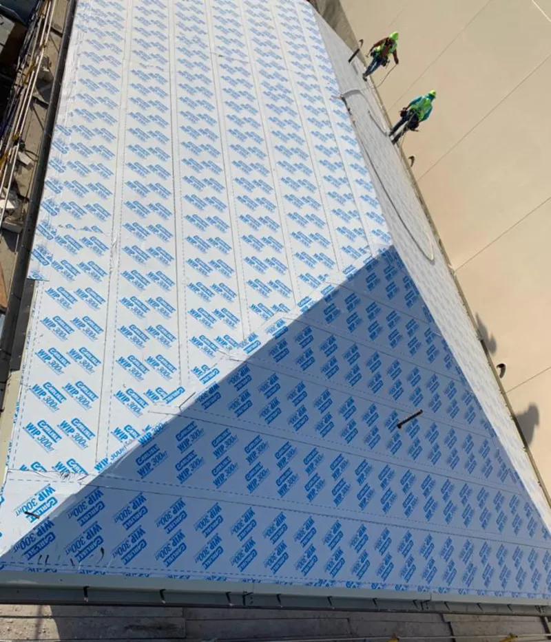 Professional roofers installing underlayment on a metal roof in Pecan Plantation